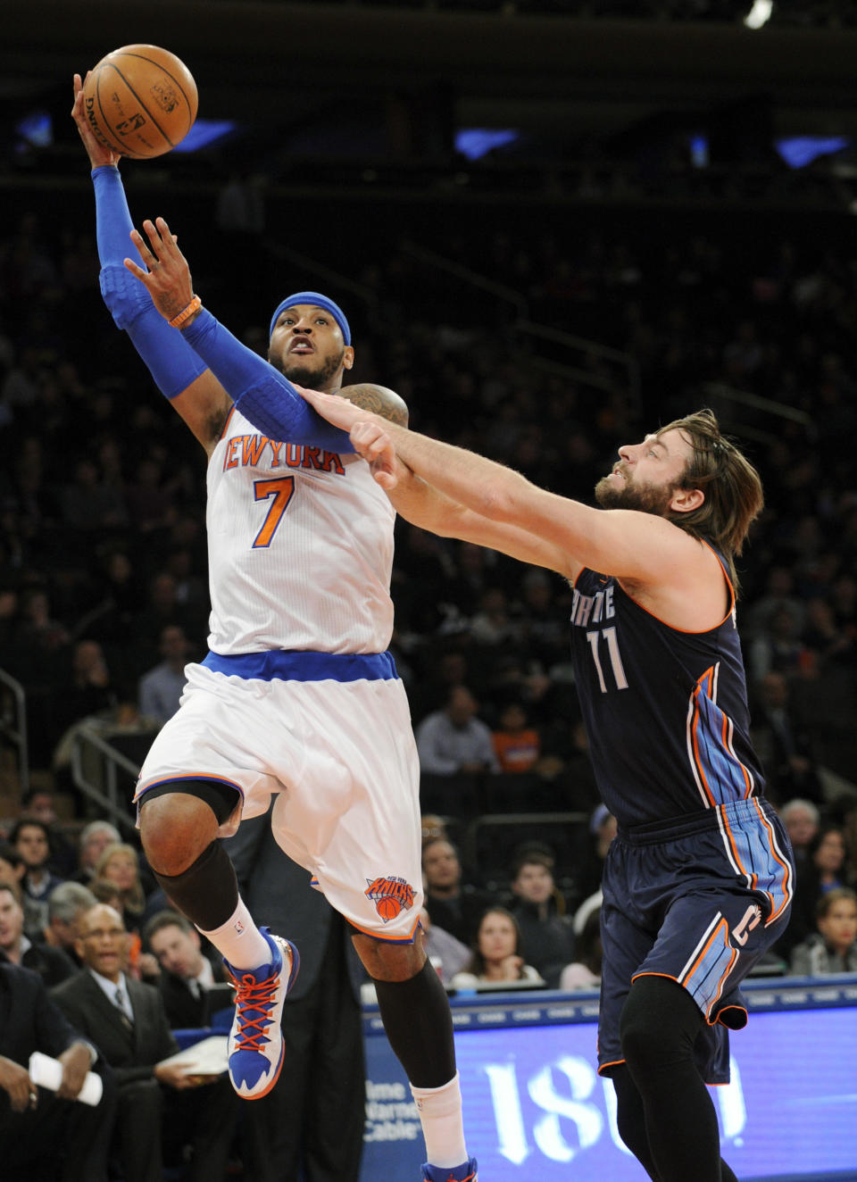 New York Knicks' Carmelo Anthony, left, puts up a shot as he gets by Charlotte Bobcats' Josh McRoberts during the first quarter of an NBA basketball game, Friday, Jan. 24, 2014, at Madison Square Garden in New York. (AP Photo/Bill Kostroun)
