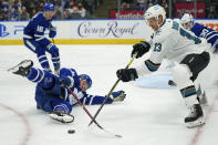 San Jose Sharks forward Nick Bonino (13) is poke-checked by Toronto Maple Leafs defenseman Morgan Rielly (44) after falling to the ice during the first period of an NHL hockey game Friday, Oct. 22, 2021, in Toronto. (Evan Buhler/The Canadian Press via AP)
