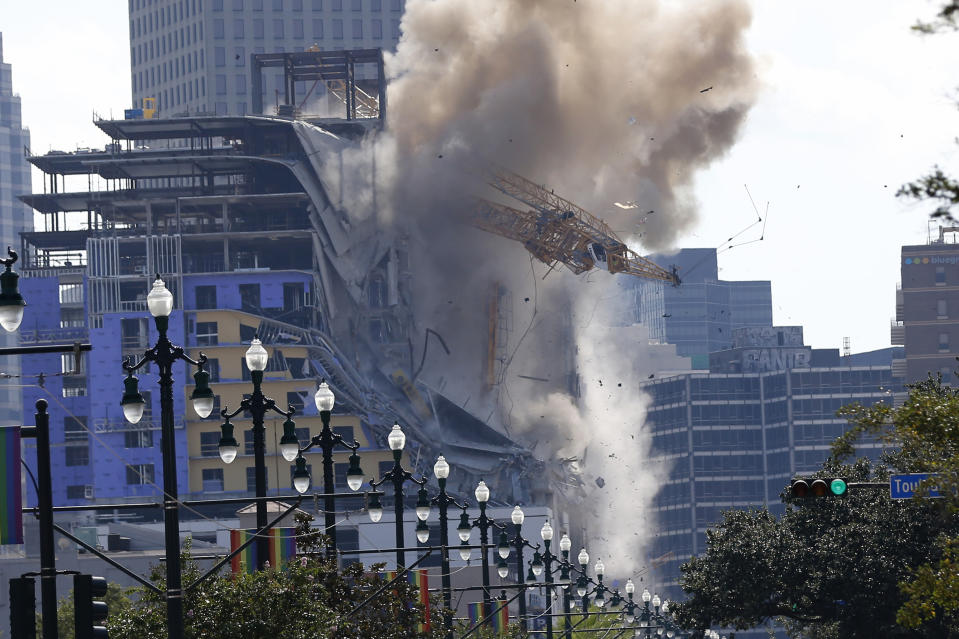 Two large cranes from the Hard Rock Hotel construction collapse come crashing down after being detonated for implosion in New Orleans, Sunday, Oct. 20, 2019. New Orleans officials set off several explosions Sunday intended to topple two cranes that had been looming over the ruins of a partially collapsed Hard Rock Hotel. (AP Photo/Gerald Herbert)