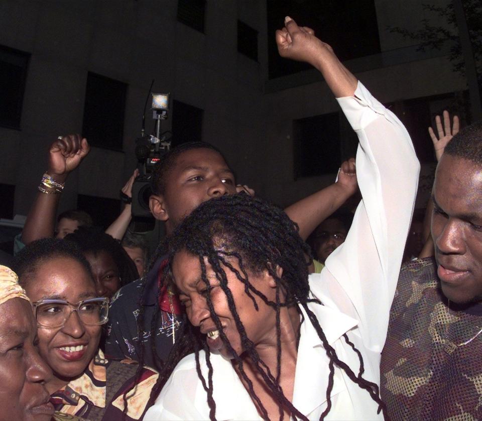 Betty Tyson raises an arm is celebration as she is released from prison, surrounded by family, friends ands well-wishers in 1998.