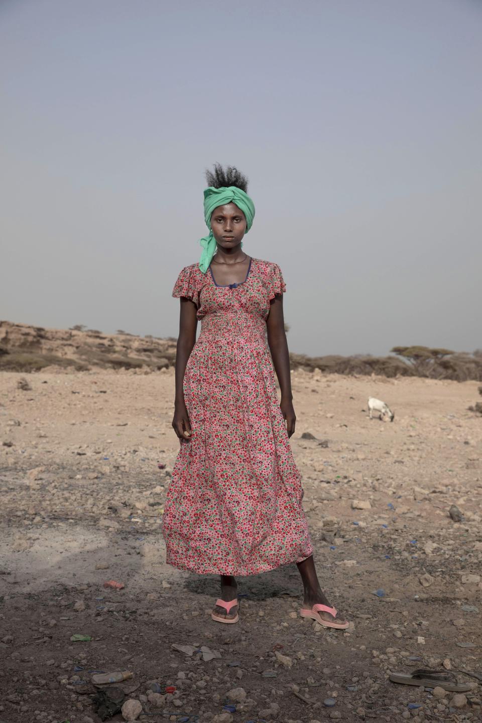 In this July 15, 2019 photo, 15-year-old Willo, a migrant from Ethiopia, poses for a portrait as she and others rest on the last stop of their journey before leaving by boat to Yemen in the evening, in Obock, Djibouti. (AP Photo/Nariman El-Mofty)