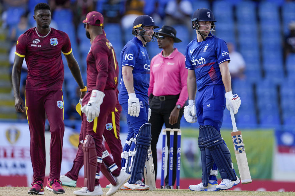 England's Phil Salt and Will Jacks chat as West Indies' captain Shai Hope talks to bowler Alzarri Joseph, left, during their first ODI cricket match at Sir Vivian Richards Stadium in North Sound, Antigua and Barbuda, Sunday, Dec. 3, 2023. (AP Photo/Ricardo Mazalan)