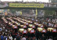 FILE - Thousands of Muslim mourners crowd as the coffins of 64 Hezbollah guerrillas are carried to a cemetery in a suburb of Beirut, July 23, 1996. Forty years since it was founded, Lebanon's Hezbollah has transformed from a ragtag organization to the largest and most heavily armed militant group in the Middle East. (AP Photo/Ali Mohamed, File)
