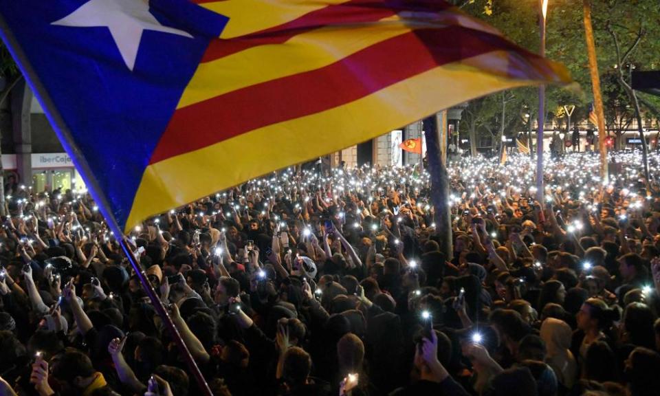 Protesters hold up their mobile phones during a demonstration in Barcelona