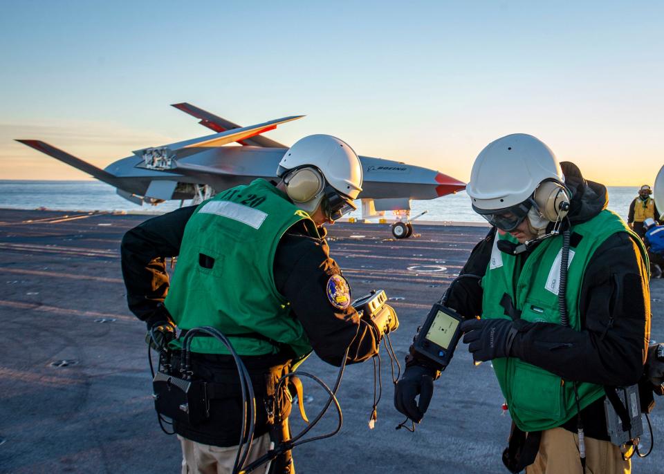 US Navy sailors operat an MQ-25 on aircraft carrier