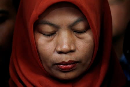 Baiq Nuril Maknun, a teacher on the island of Lombok who was jailed after she tried to report sexual harassment, reacts during a press conference with Indonesia's Law and Human Rights Minister Yasonna Laoly in Jakarta