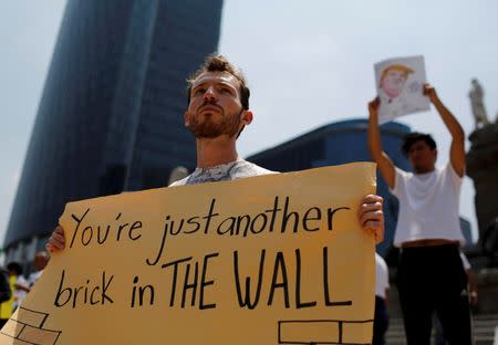 Demonstrators hold placards during a protest against the visit of Donald Trump, at the Angel of Independence monument in Mexico City. REUTERS/Tomas Bravo