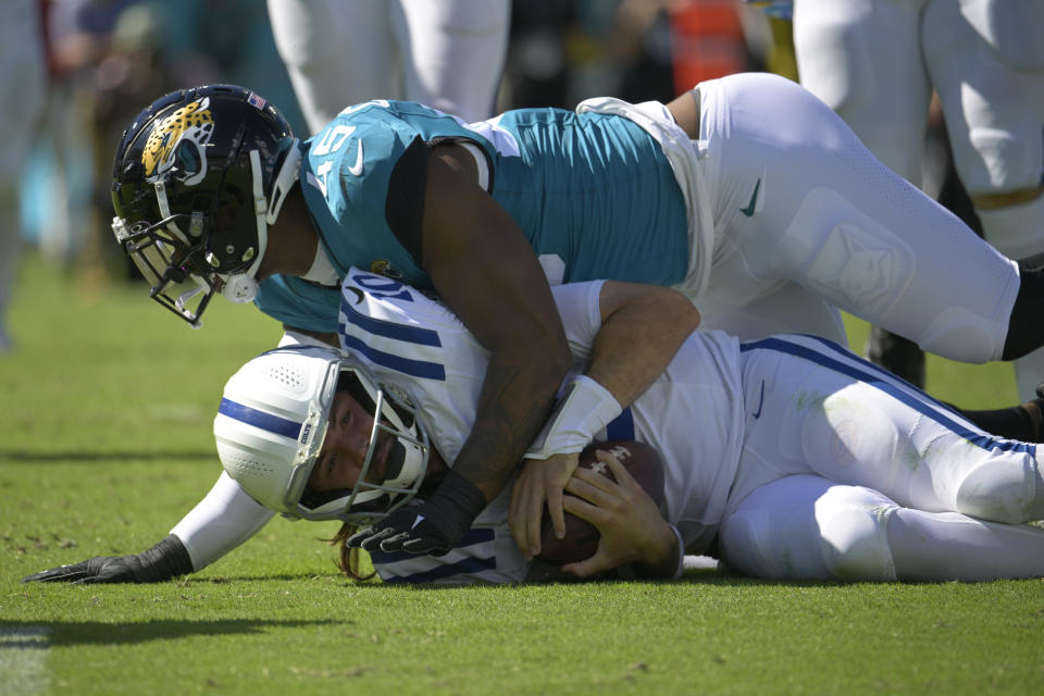 Indianapolis Colts quarterback Gardner Minshew (10) is tackled by Jacksonville Jaguars linebacker K'Lavon Chaisson (45) during the second half of an NFL football game, Sunday, Oct. 15, 2023, in Jacksonville, Fla. (AP Photo/Phelan M. Ebenhack)