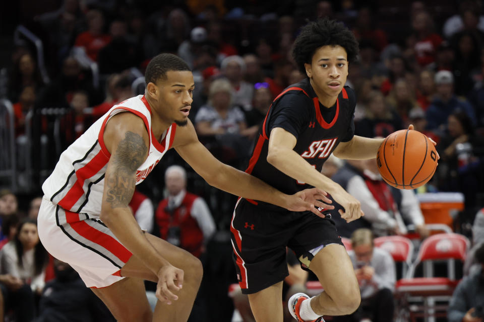 Saint Francis' Cam Gregory, right, brings the ball up court against Ohio State's Roddy Gayle during the first half of an NCAA college basketball game on Saturday, Dec. 3, 2022, in Columbus, Ohio. (AP Photo/Jay LaPrete)