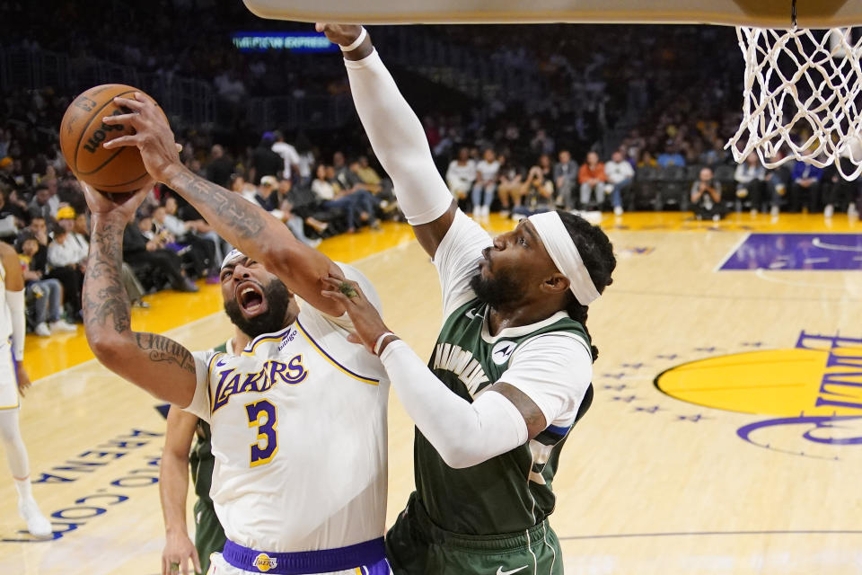Los Angeles Lakers forward Anthony Davis, left, shoots as Milwaukee Bucks forward Jae Crowder defends during the first half of an NBA preseason basketball game Sunday, Oct. 15, 2023, in Los Angeles. (AP Photo/Mark J. Terrill)