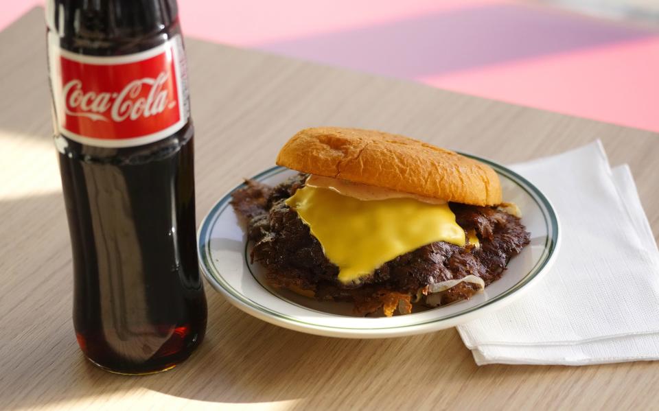 A double burger and a Coke on a table at Bad Jimmy's in Phoenix on Nov. 28, 2023.