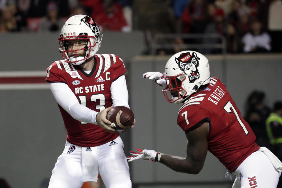 North Carolina State quarterback Devin Leary (13) hands off to running back Zonovan Knight (7) during the first half of the team's NCAA college football game against North Carolina on Friday, Nov. 26, 2021, in Raleigh, N.C. (AP Photo/Chris Seward)