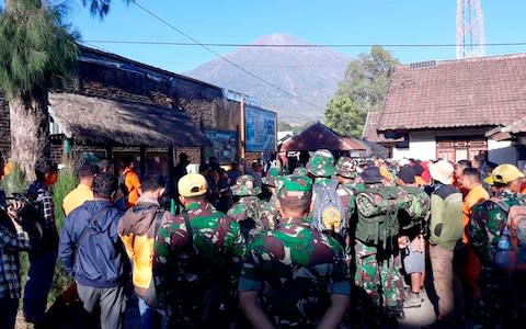 Indonesian soldiers and rescue team gather to prepare for evacuating tourists from Mount Rinjani - Credit: AP