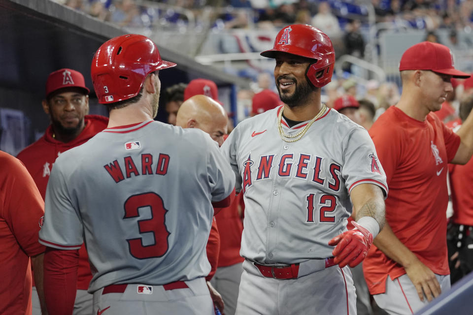 Los Angeles Angels' Taylor Ward (3) and Aaron Hicks (12) congratulate each other after scoring during the third inning of a baseball game against the Miami Marlins, Wednesday, April 3, 2024, in Miami. (AP Photo/Marta Lavandier)