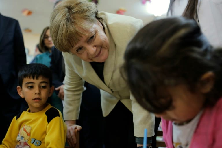 German Chancellor Angela Merkel talks with refugee children at a preschool, during a visit to a refugee camp on the Turkish-Syrian border