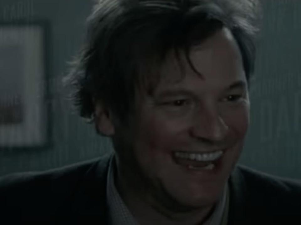 Colin Firth smiling wildly with disheveled hair.