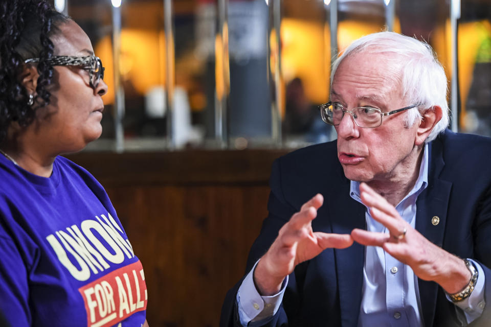 Artinese Malachi, of Swissvale, Pa. and SEIU union LPN, left, listens as U.S. Sen. Bernie Sanders, Democratic presidential candidate speaks during a roundtable discussion with UPMC Hospitals and SEIU healthcare workers prior to his attendance at the presidential candidate Public Education Forum, Saturday, Dec. 14, 2019, on Locust Street in Uptown. (Pittsburgh Post-Gazette via AP)