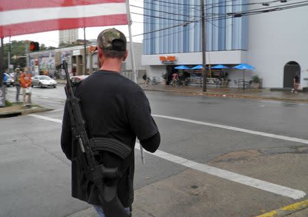 A pro-gun advocate walks down the street outside the University of Texas ahead of a 'mock mass shooting' event where they used cardboard cut-outs rifles, the simulated bangs of bullets on bullhorns and doused fake victims with fake blood, in Austin, Texas, December 12, 2015. REUTERS/Jon Herskovitz