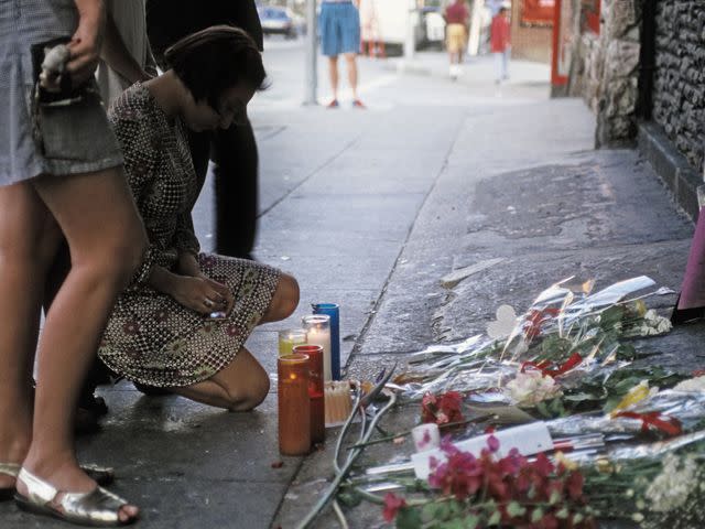 <p>Michael Ochs Archives/Getty</p> Fans placing flowers, candles and notes outside of The Viper Room on Nov. 1, 1993.