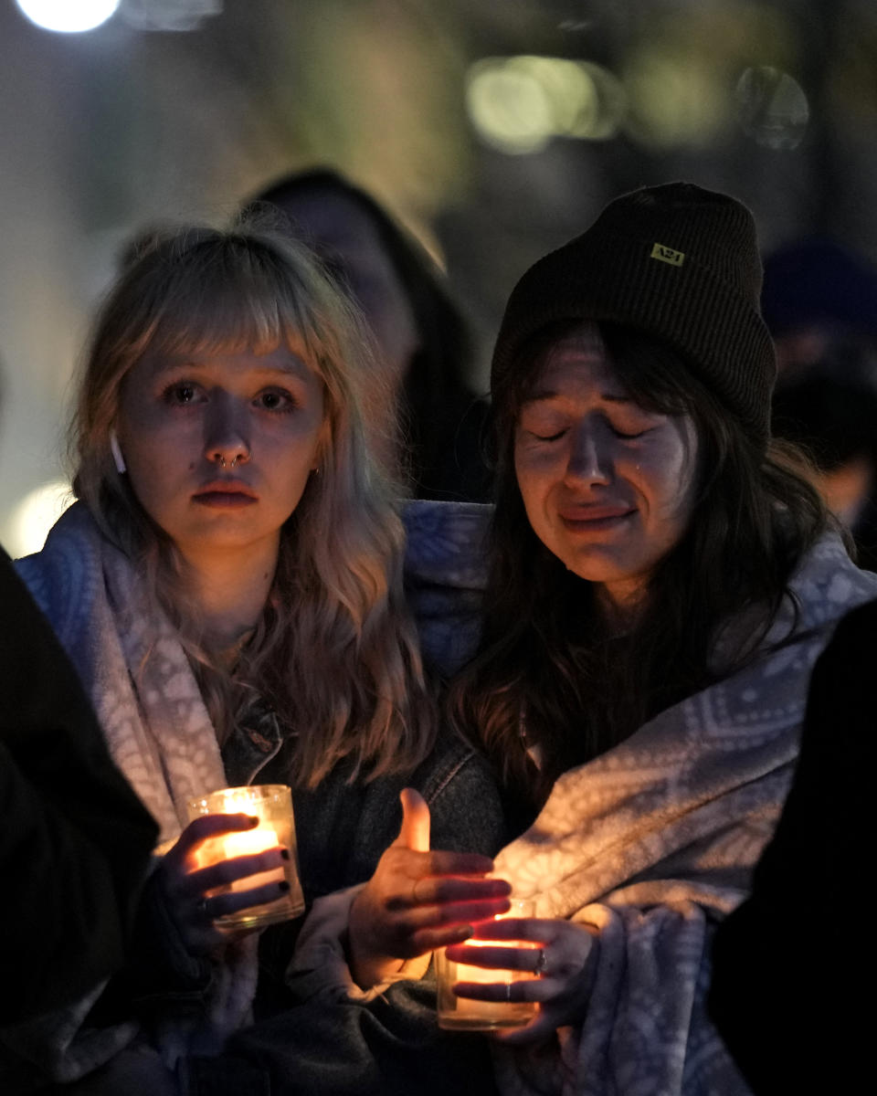 Abbie Lewis, left, and Jackie Batista-Martinez attend a candlelight vigil for victims of a shooting at a Kansas City Chiefs Super Bowl victory rally Thursday, Feb. 15, 2024 in Kansas City, Mo. More than 20 people were injured and one woman killed in the shooting near the end of Wednesday's rally held at nearby Union Station. (AP Photo/Charlie Riedel)