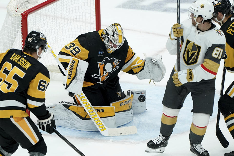 Pittsburgh Penguins goaltender Alex Nedeljkovic reaches to stop a puck in front of Vegas Golden Knights' Jonathan Marchessault during the third period of an NHL hockey game, Sunday, Nov. 19, 2023, in Pittsburgh. (AP Photo/Matt Freed)