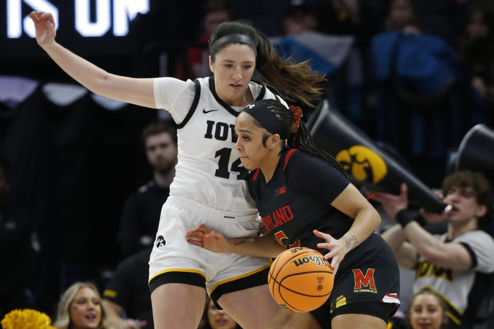 Maryland guard Brinae Alexander, right, goes to the basket as Iowa guard McKenna Warnock defends her in the first half of an NCAA college basketball game at the Big Ten women's tournament Saturday, March 4, 2023, in Minneapolis. (AP Photo/Bruce Kluckhohn)