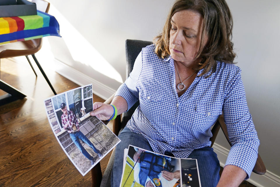 June Linnertz poses with photos of her father at her Chaska, Minn., home, Wednesday, Nov. 11, 2020. Her father, James Gill, 78, died of Lewy Body Dementia at Cherrywood Pointe in Plymouth, according to a copy of his death certificate provided to The Associated Press. Linnertz always expected her father to die of the condition, which causes a progressive loss of memory and movement, but never thought he would end his days in so much pain, suffering needlessly. (AP Photo/Jim Mone)
