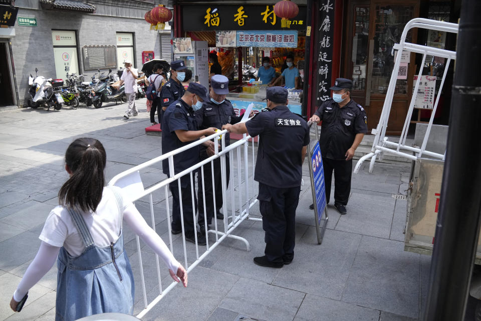 Security officers put up access control barriers along a pedestrian shopping street in a neighborhood popular with tourists in central Beijing, Tuesday, Aug. 3, 2021. From the Great Wall to the picturesque Kashmir valley, Asia's tourist destinations are looking to domestic visitors to get them through the COVID-19 pandemic's second year. With international travel heavily restricted, foreign tourists can't enter many countries and locals can't get out. (AP Photo/Mark Schiefelbein)
