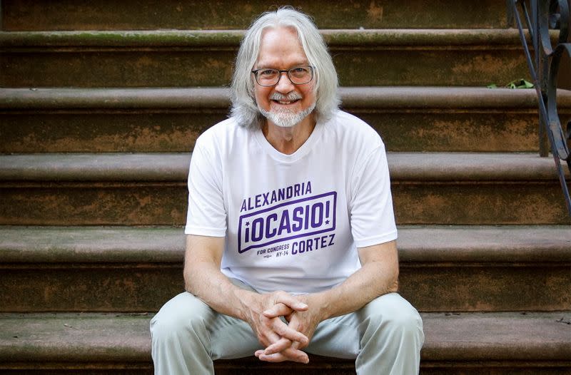 Peter Hogness poses wearing his Alexandria Ocasio-Cortez branded T-shirt in the Park Slope area of Brooklyn, New York