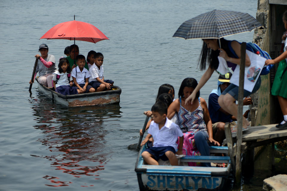 Filipino elementary school students ride on boats to go to Panghulo Elementary School near the Artex Compound in Malabon City in the Philippines on June 5, 2013. 