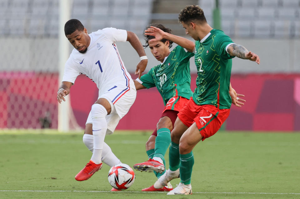 France's forward Arnaud Nordin (L) is marked by Mexico's forward Diego Lainez (C) and Mexico's defender Jorge Sanchez during the Tokyo 2020 Olympic Games men's group A first round football match between Mexico and France at Tokyo Stadium in Tokyo on July 22, 2021. (Photo by Mariko Ishizuka / AFP) (Photo by MARIKO ISHIZUKA/AFP via Getty Images)