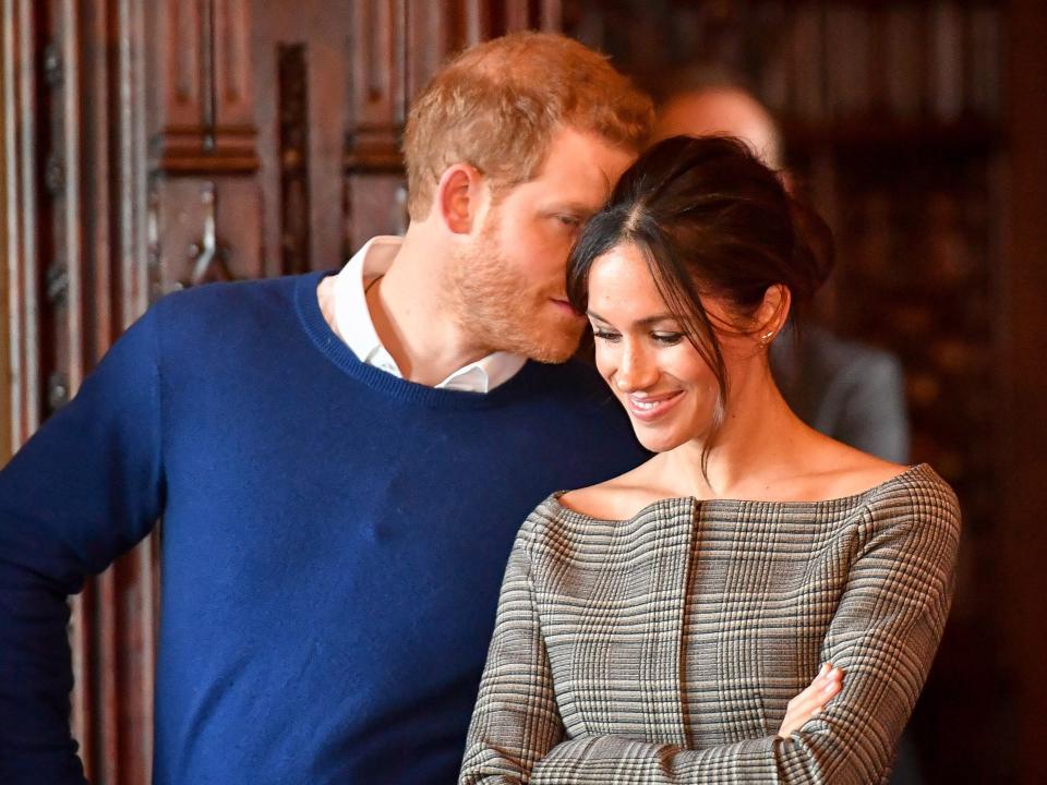 Prince Harry whispers to Meghan Markle.