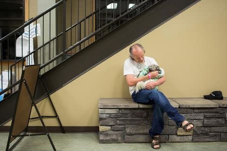 A resident of Fort McMurray embraces his dog while at the Bold Centre in Lac La Biche, Alberta, Canada, where evacuees have been living since leaving their Fort McMurray homes due to the raging wildfires on May 9, 2016. REUTERS/Topher Seguin