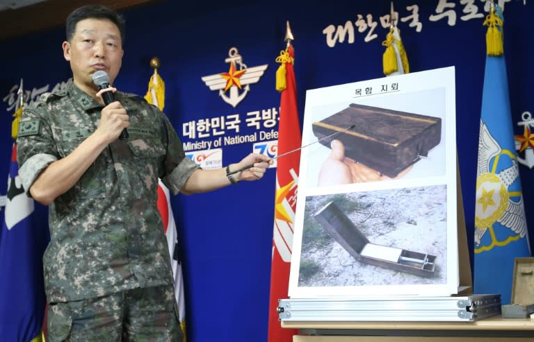 A South Korean military officer shows pictures of North Korean "wooden box" land mines during a briefing at the Defence Ministry in Seoul on August 10, 2015