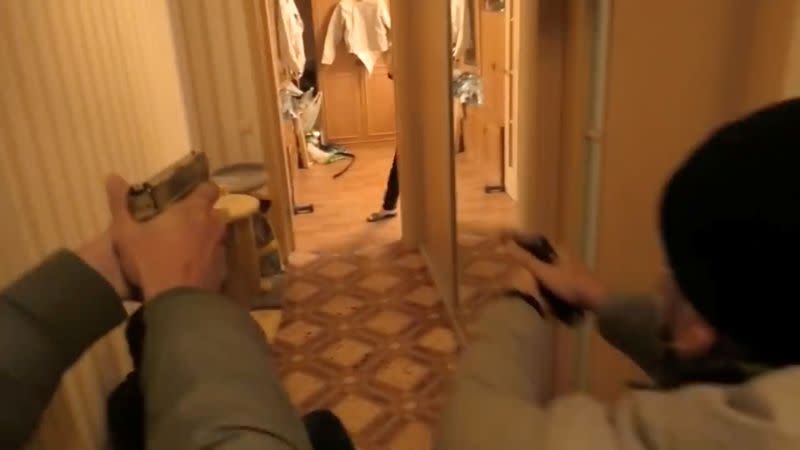 Belarusian security officers enter an apartment during a raid in Minsk