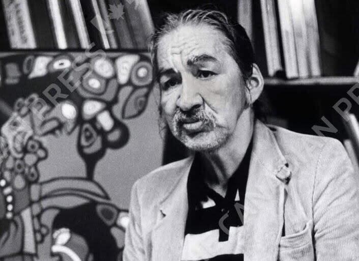 Norval Morrisseau, shown with one of his earlier paintings at a Vancouver gallery on May 11, 1987, was a renowned artist from the Ojibway Bingwi Neyaashi Anishinaabek First Nation in northwestern Ontario.  (Chuck Stoody/The Canadian Press - image credit)