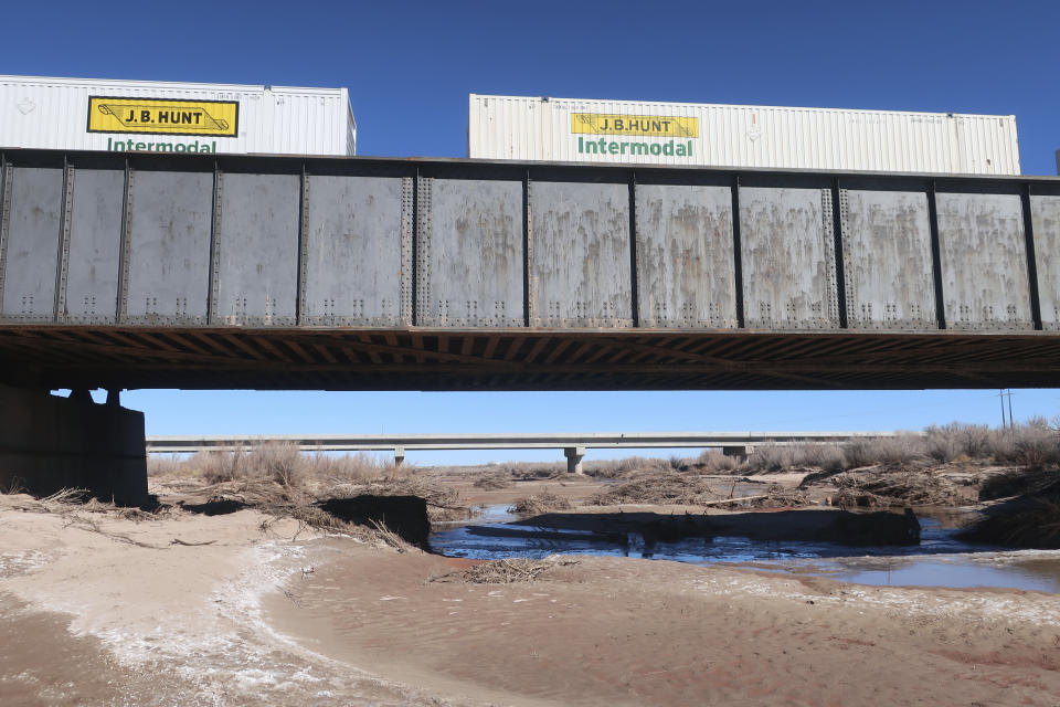 FILE - A train travels along a bridge that goes over the Little Colorado River in Winslow, Ariz., Feb. 4, 2022. A proposed water rights settlement for three Native American tribes that carries a price tag larger than any such agreement enacted by Congress took a significant step forward late Monday, May 13, with introduction in the Navajo Nation Council. (AP Photo/Felicia Fonseca, File)