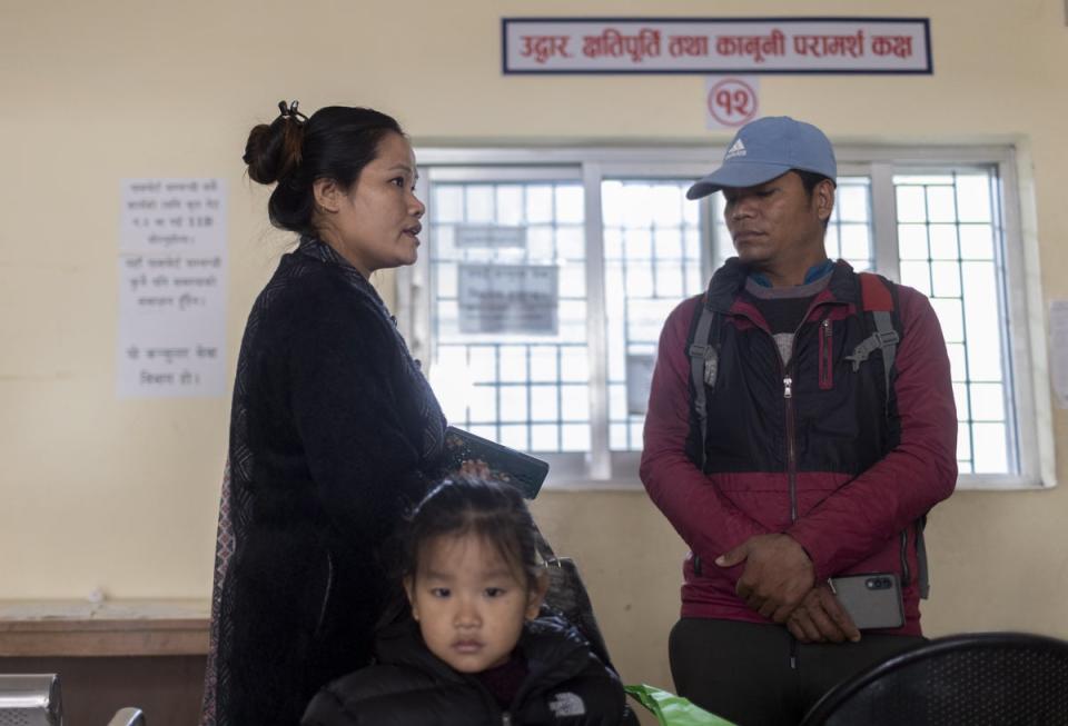 Sanu Kanchi Tumbape (L), along with her brother, submits an appeal letter seeking assistance to rescue her husband, Suresh Tumbape, at the Nepalese Foreign Ministry in Kathmandu (EPA)