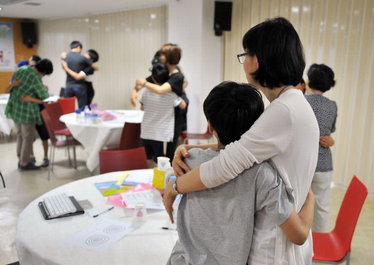 Children hug their parents during a clinic for smartphone addiction, at a church in Seoul, on June 8, 2013. South Korea, after boasting for years advanced technology from high-speed Internet to Samsung smartphones, is now taking pains to try to pull its tech-crazed youth away from digital addiction