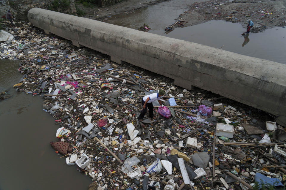 Men participate in a cleanup effort for the Bagmati River in Kathmandu, Nepal, Saturday, May 28, 2022. Mala Kharel, an executive member of a governmental committee set up to help clean up the river, said that over the years the campaign has succeeded in collecting about 80% of garbage along the riverbank. But the pickup efforts admittedly fall short, in part since frequent disruptions to trash collection services encourage more dumping than they can keep up with. (AP Photo/Niranjan Shrestha)