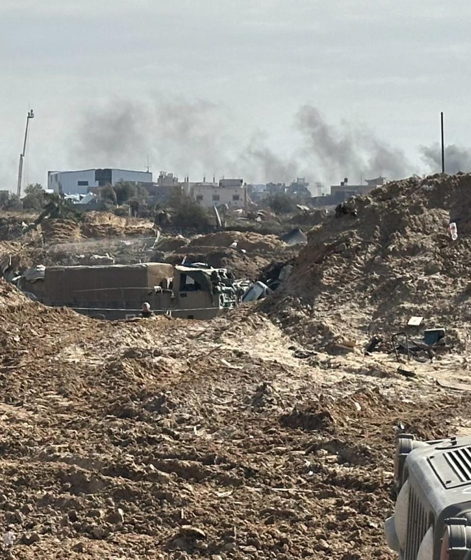 Smoke rises in the distance from a Gaza battlefield.