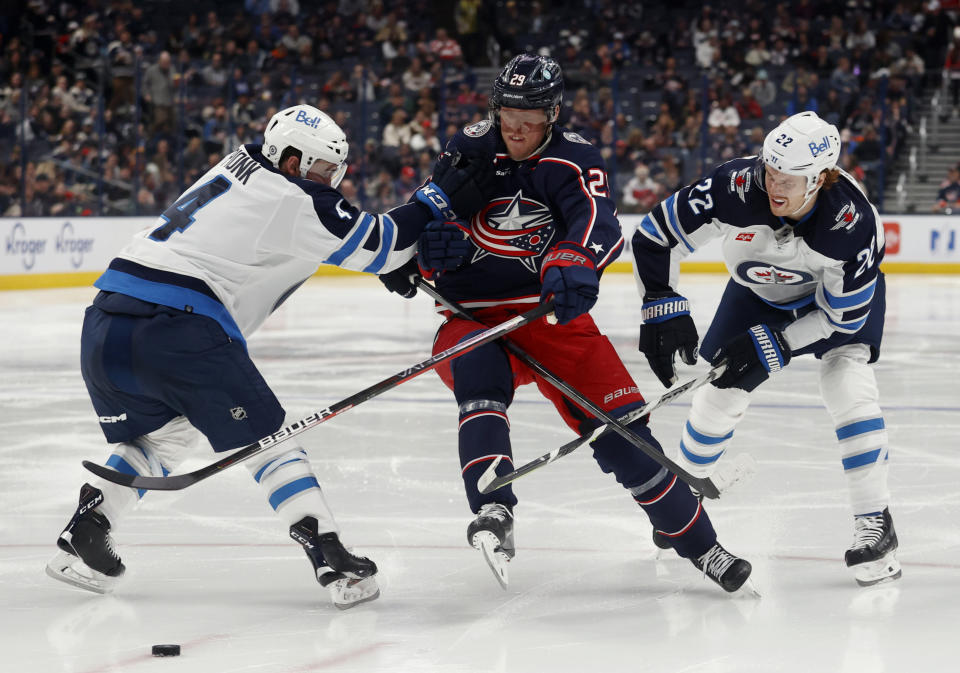 Columbus Blue Jackets forward Patrik Laine, center, chases the puck between Winnipeg Jets defenseman Neal Pionk, left, and forward Mason Appleton during the second period of an NHL hockey game in Columbus, Ohio, Thursday, Feb. 16, 2023. (AP Photo/Paul Vernon)