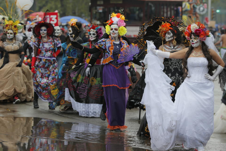 Women dressed as Catrinas participate in the Day of the Dead parade in Mexico City, Saturday, Nov. 2, 2019. (AP Photo/Ginnette Riquelme)