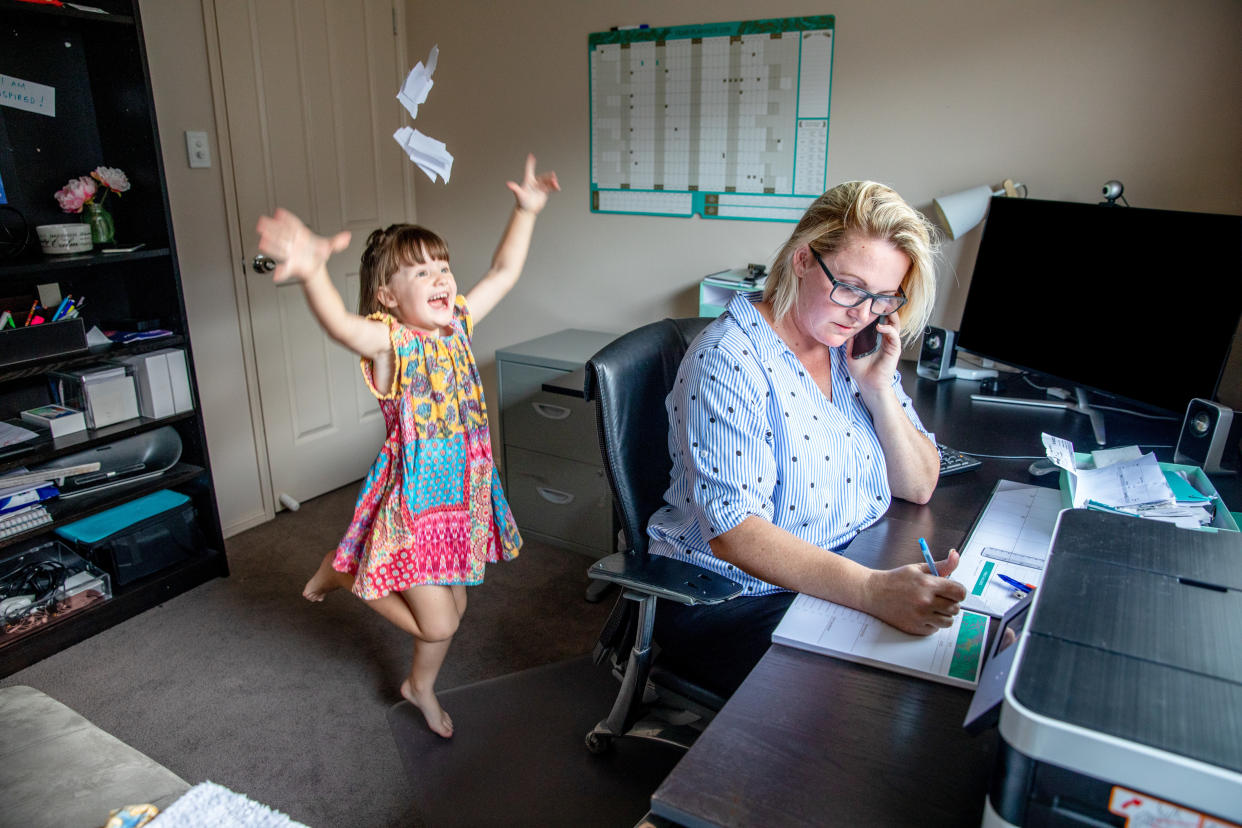 Mother attempts to work from home on the computer and phone whilst her daughter copies her, makes a mess and throws the laundry around.