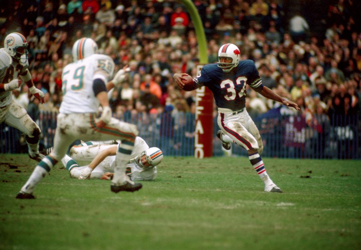 Bills running back O.J. Simpson looks for running room against the Dolphins' Doug Swift (59) and Vern Den Herder (83).