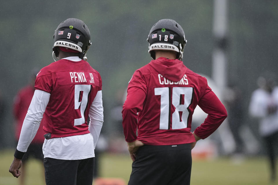 Atlanta Falcons quarterbacks Kirk Cousins, right, and Michael Penix Jr., run drills during an NFL football mini training camp practice on Tuesday, May 14, 2024, in Flowery Branch, Ga. (AP Photo/Brynn Anderson)