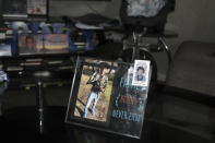 A picture of Marcqueon Jaquez Goodman sits on a table in front of another picture of him in his home in Charlotte, N,C., on July 8, 2021. Goodman was 16 when he was shot to death on April, 29, 2021 in Charlotte. Homicide rates in many American cities have continued to rise although not as precipitously as the double-digit jumps seen in 2020 and still below the violence of the mid-90s. (AP Photo/Skip Foreman)