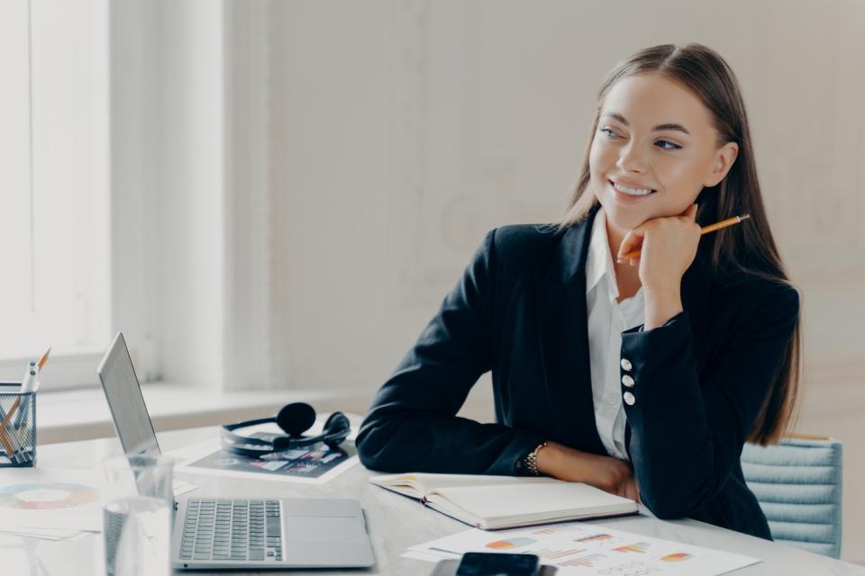 A smiling investor sitting at a desk.