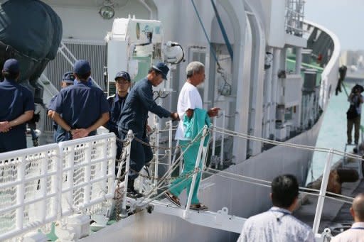 A pro-China activist (C), one of 14 that landed on the disputed island known as Senkaku in Japan and Diaoyu in China, is arrested by police at Naha port on Japan's sourthern island of Okinawa, on August 16. Japan is now considering what to do with the arrested activists as Beijing has angrily demanded their immediate release