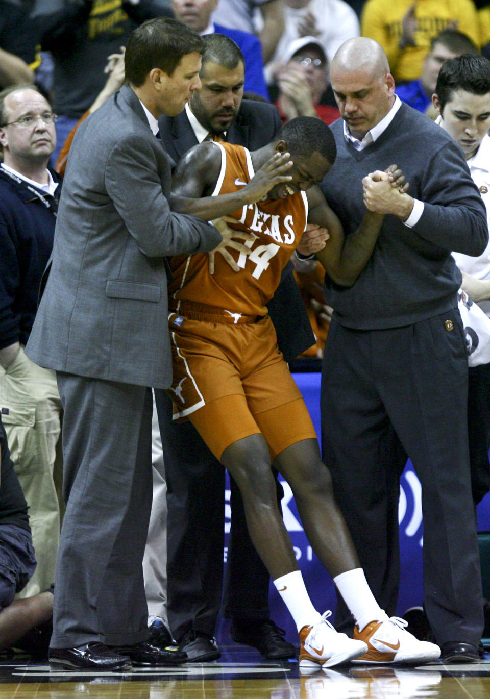 KANSAS CITY, MO - MARCH 09: J'Covan Brown #14 of the Texas Longhorns is helped to his feet after being injured while playing against the Missouri Tigers in the second half during the semifinals of the Big 12 Basketball Tournament March 09, 2012 at Sprint Center in Kansas City, Missouri. (Photo by Ed Zurga/Getty Images)